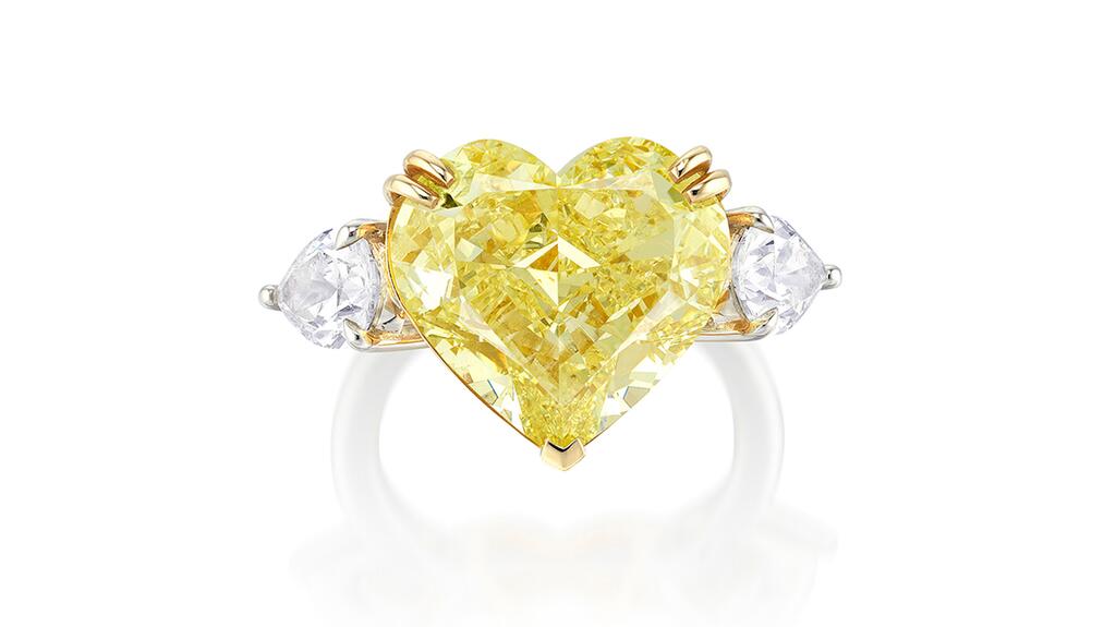 This ring featuring an 11-carat heart-shaped fancy yellow diamond between two pear-shaped diamonds mounted in white and yellow gold sold for more than $130,000. heart shaped yellow diamond 11.08 carats